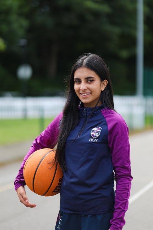 A female pupil holding a basketball