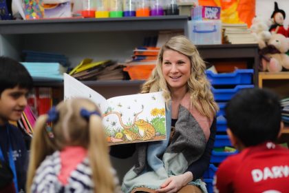 A female teacher reading to a group of children