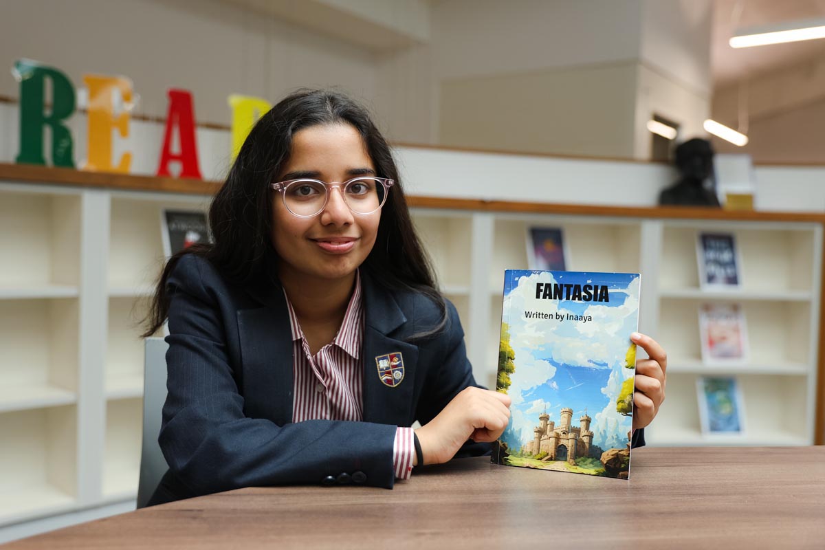 A girl with glasses, holding a book