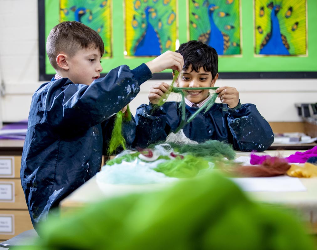 Two young boys working together on a school art project