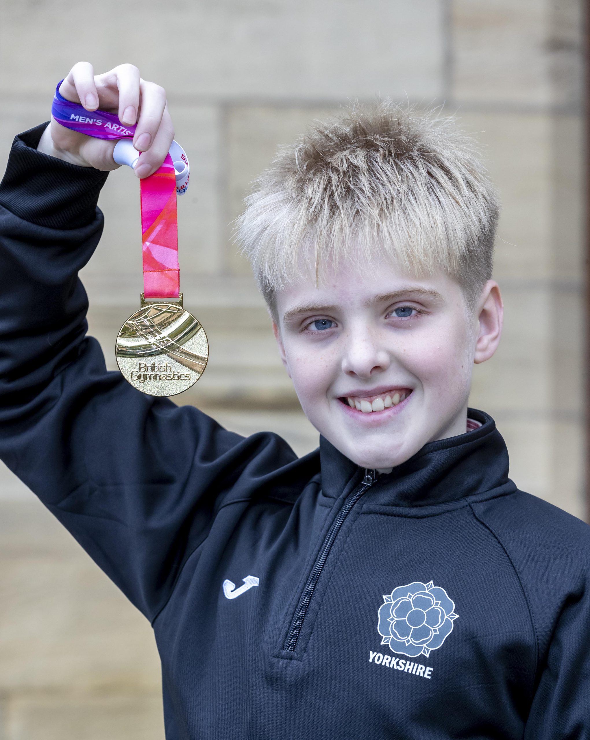 Isaac smiling holding his gold medal